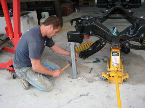 Paul installing the coil springs in his 59 Cadillac with the help of a home made bracket.